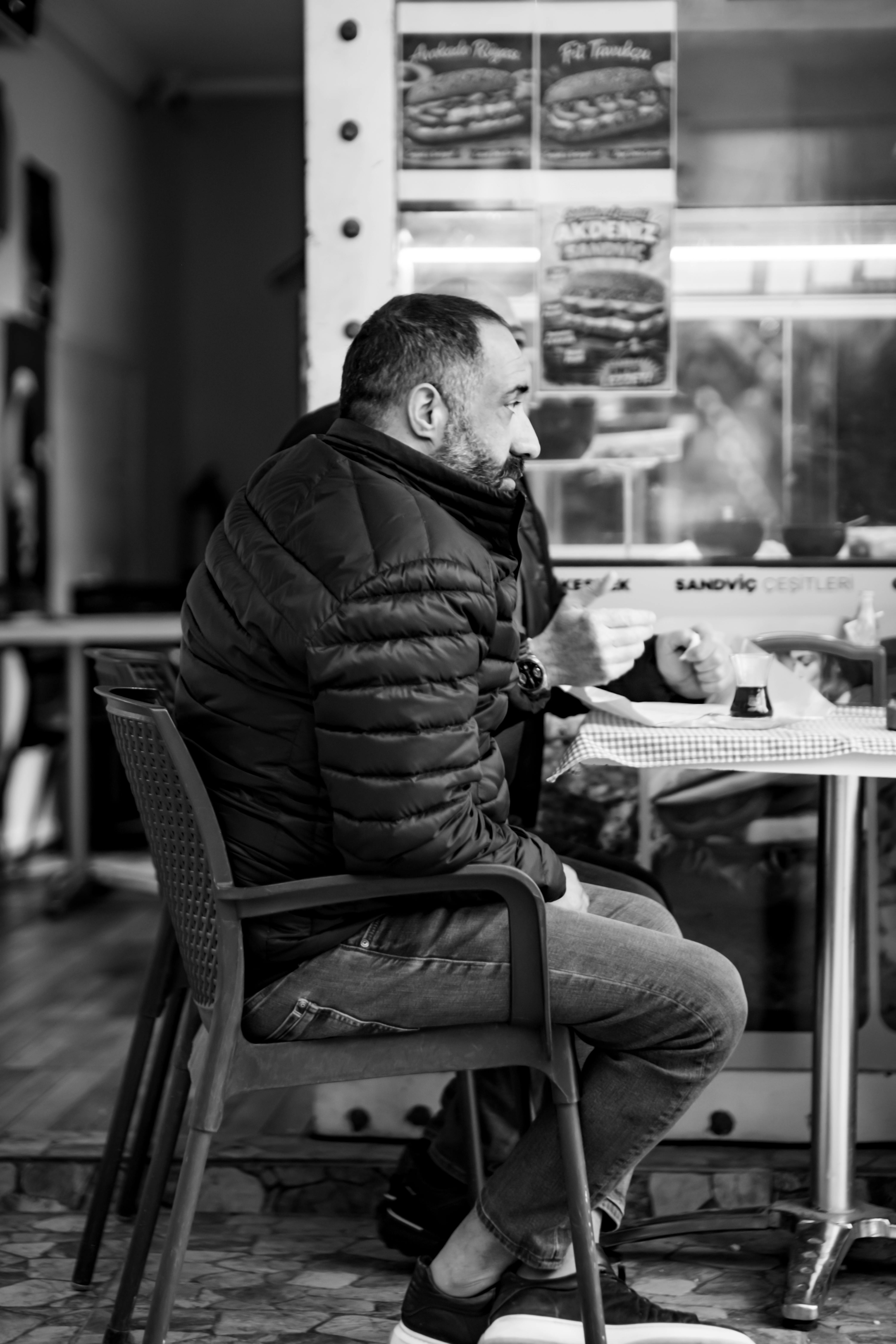 Δωρεάν Ένας άντρας με ζεστή ενδυμασία απολαμβάνει καφέ μέσα σε ένα άνετο καφέ. Ασπρόμαυρο πορτρέτο. Φωτογραφία από στοκ φωτογραφιών