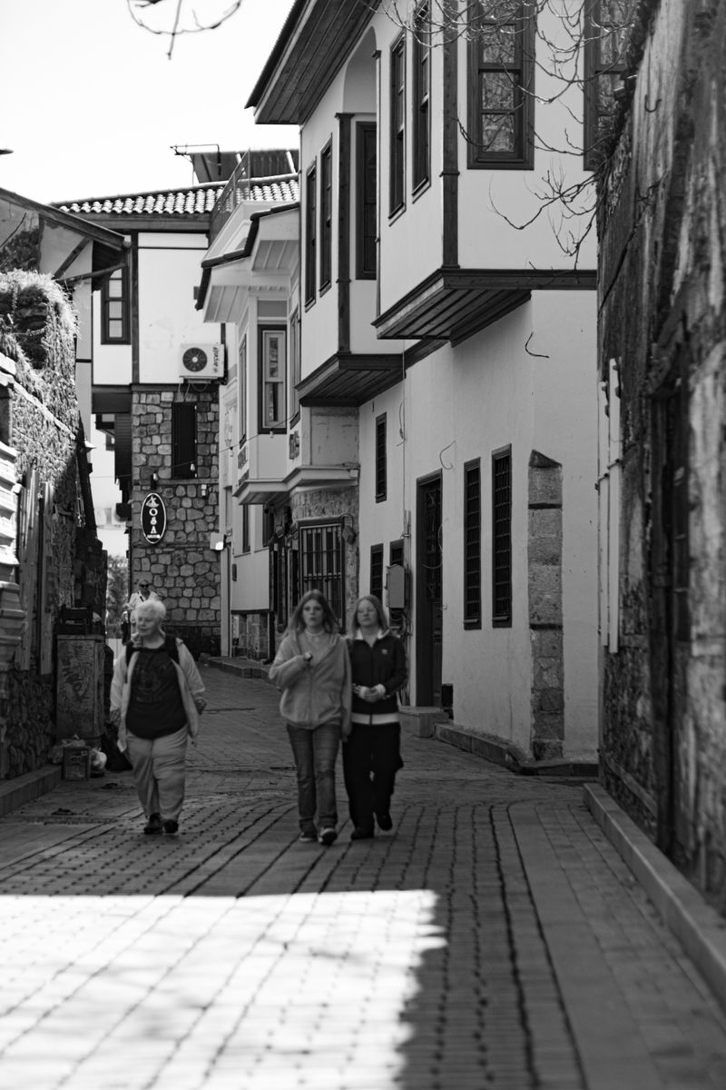 A picturesque black and white street scene capturing people walking in a historic old town.