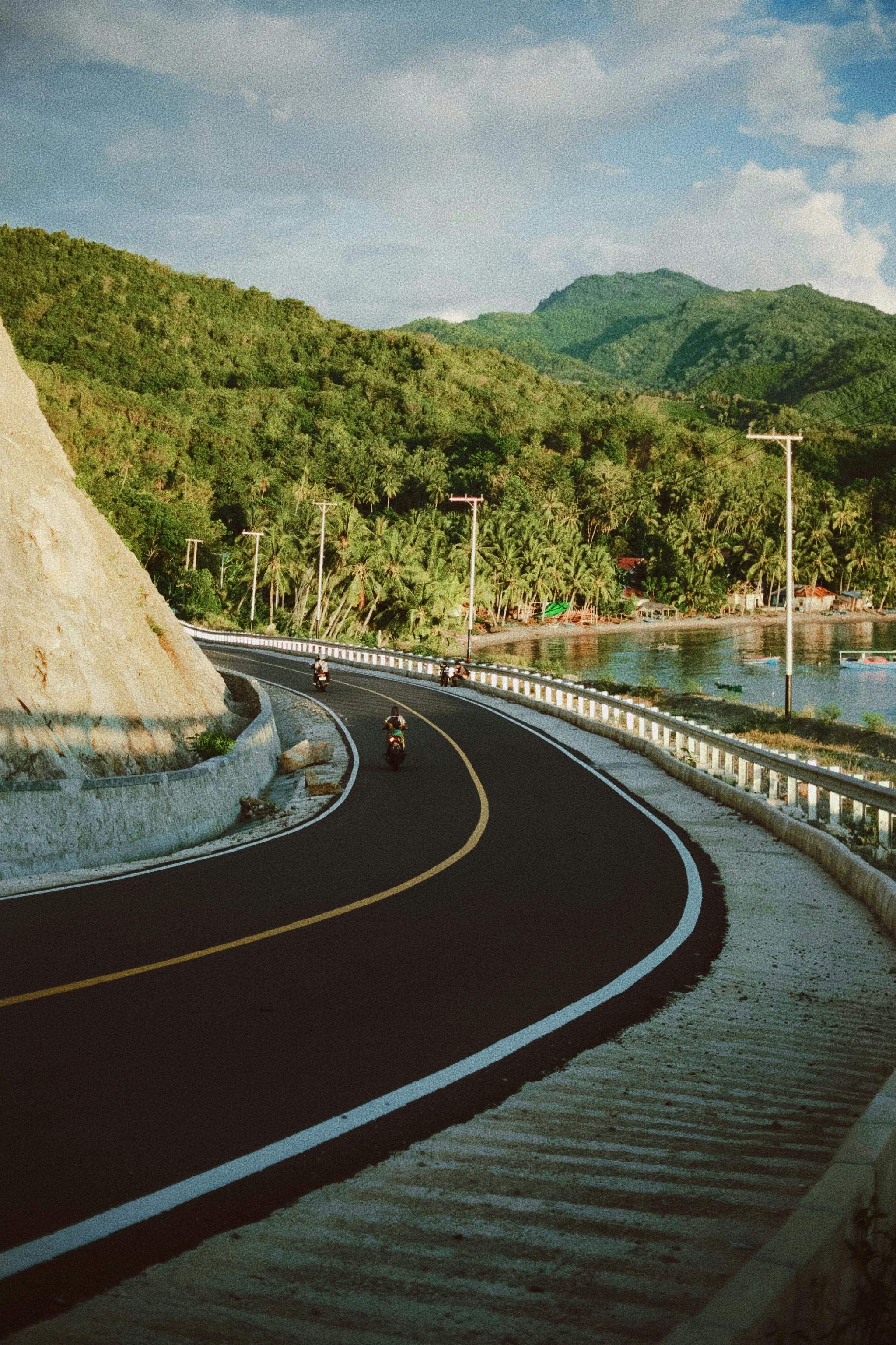 бесплатная Живописная дорога в Билунгала, Индонезия, в окружении зеленых холмов и чистого неба. Стоковое фото