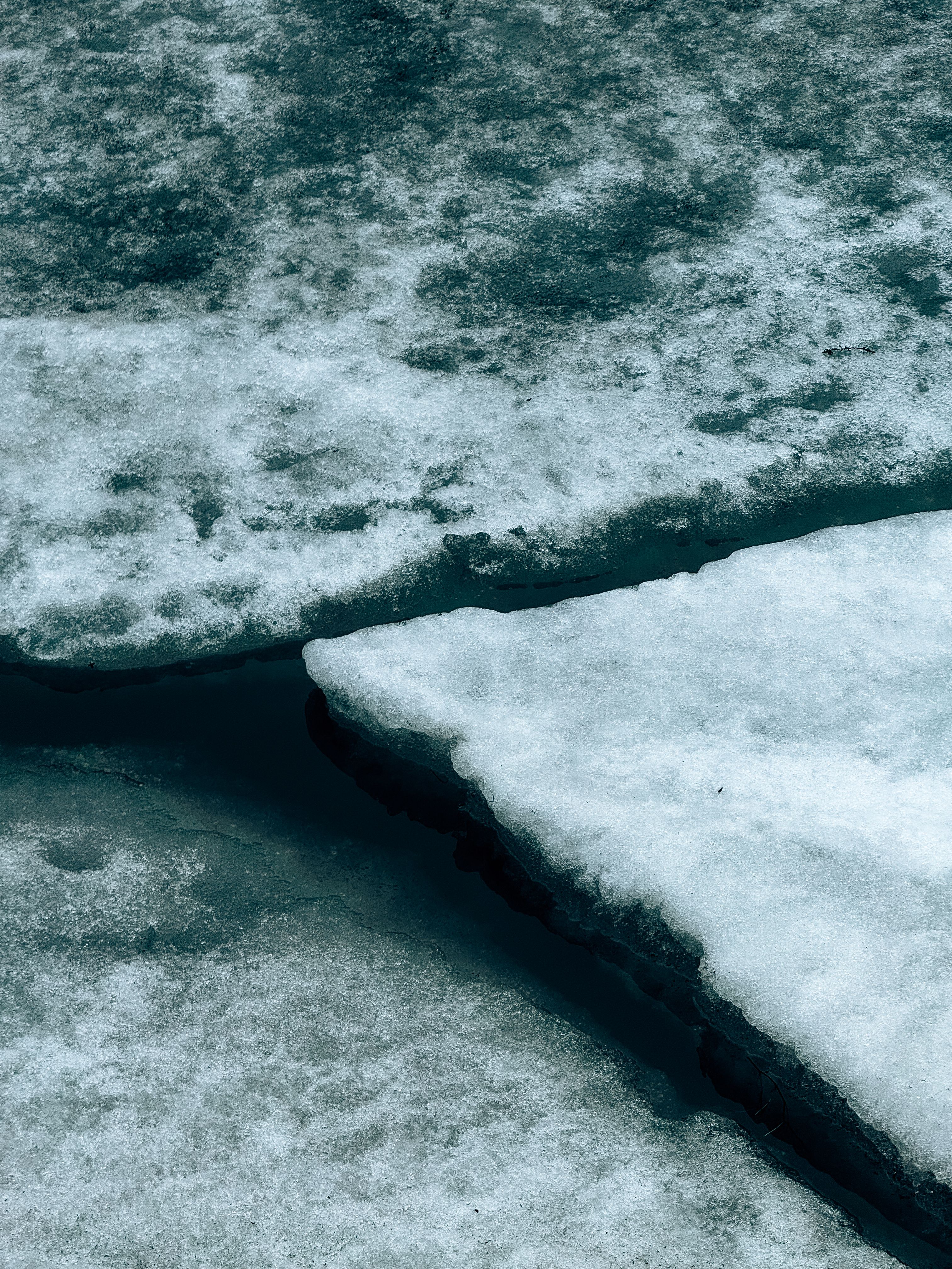 A detailed view of cracked ice formations floating on water, showcasing winter texture.. detailed, view, cracked