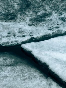 A detailed view of cracked ice formations floating on water, showcasing winter texture.. detailed, view, cracked