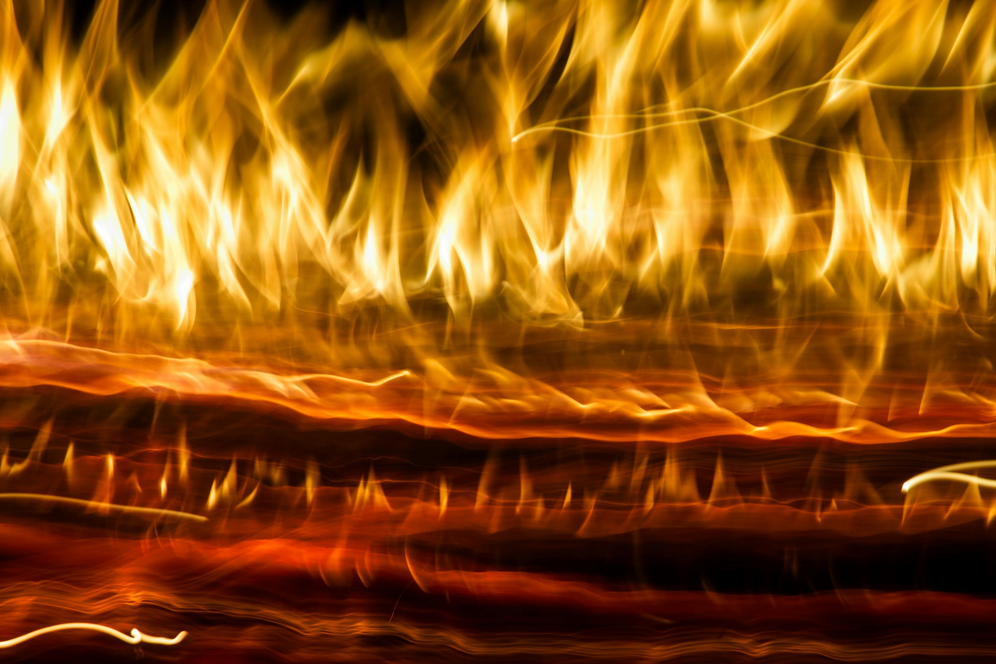 бесплатная Динамичная абстрактная фотография с огненными световыми полосами и размытием, создающим эффект свечения в движении. Стоковое фото