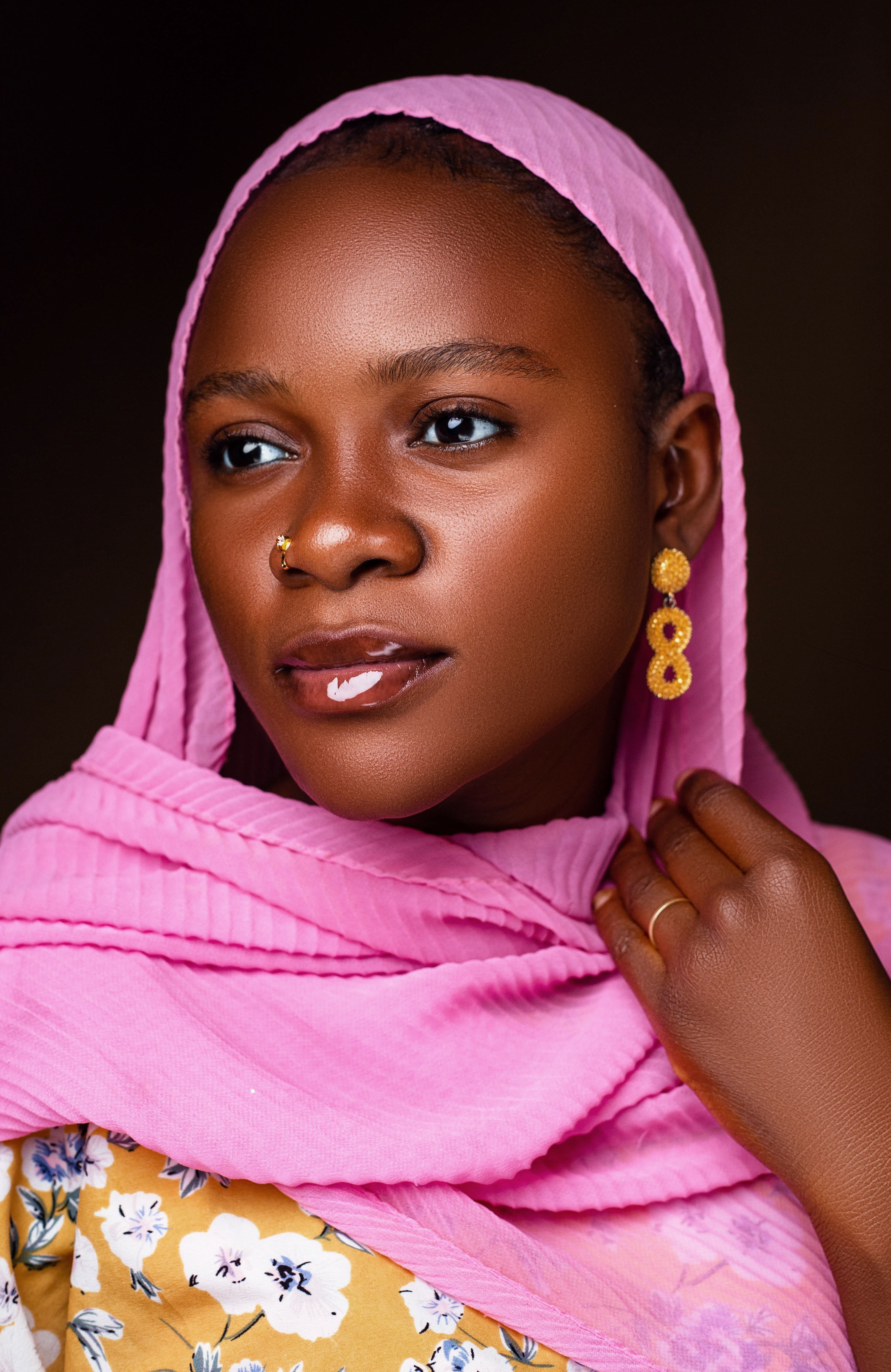 Vibrant portrait of a woman wearing pink scarf and floral top, showcasing beauty and cultural elegance.