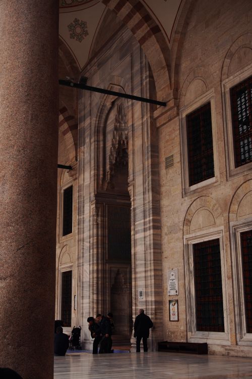 Free Visitors admire the intricate architecture of a historic mosque interior. Stock Photo