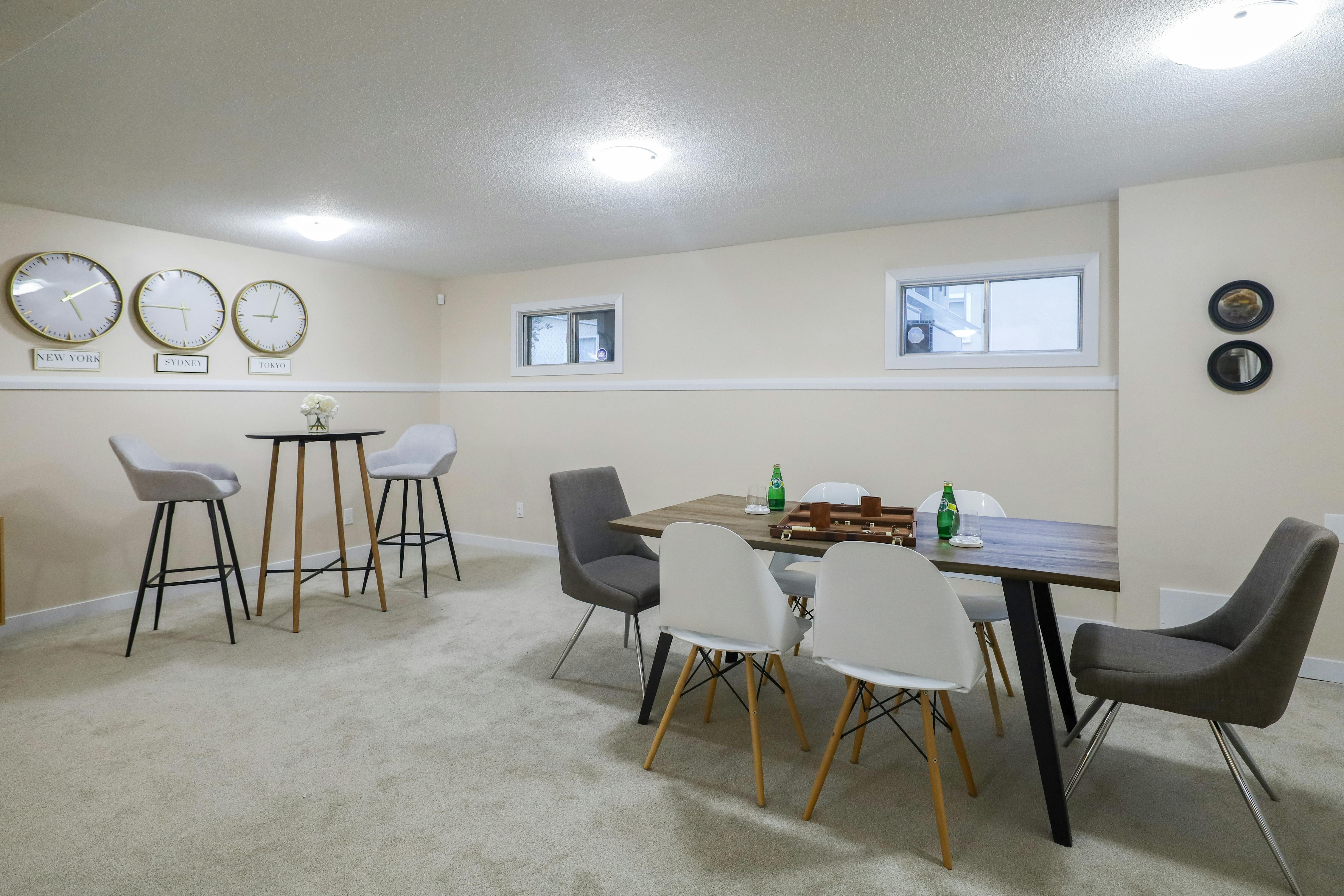 無料 カナダのエドモントンにある、ミニマリストな装飾が施されたスタイリッシュでエレガントな地下のダイニングとリビング エリア。 写真素材