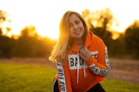 黄金时段，一名身穿鲜艳连帽衫的女子在拉巴特公园微笑着