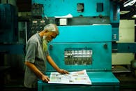 Man reviewing prints at a printing press