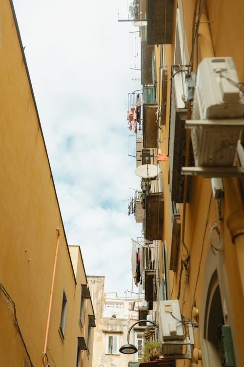 Free Charming view of narrow street between colorful European buildings with balconies. Stock Photo