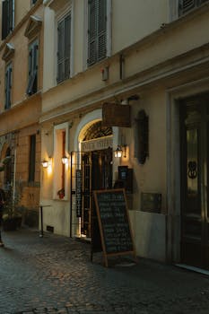 Charming Italian restaurant entrance with warm lights and cobblestone street, perfect for a cozy dining evening.