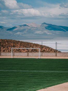 A lush soccer field against the stunning mountain landscape of Olaroz Chico, Jujuy.