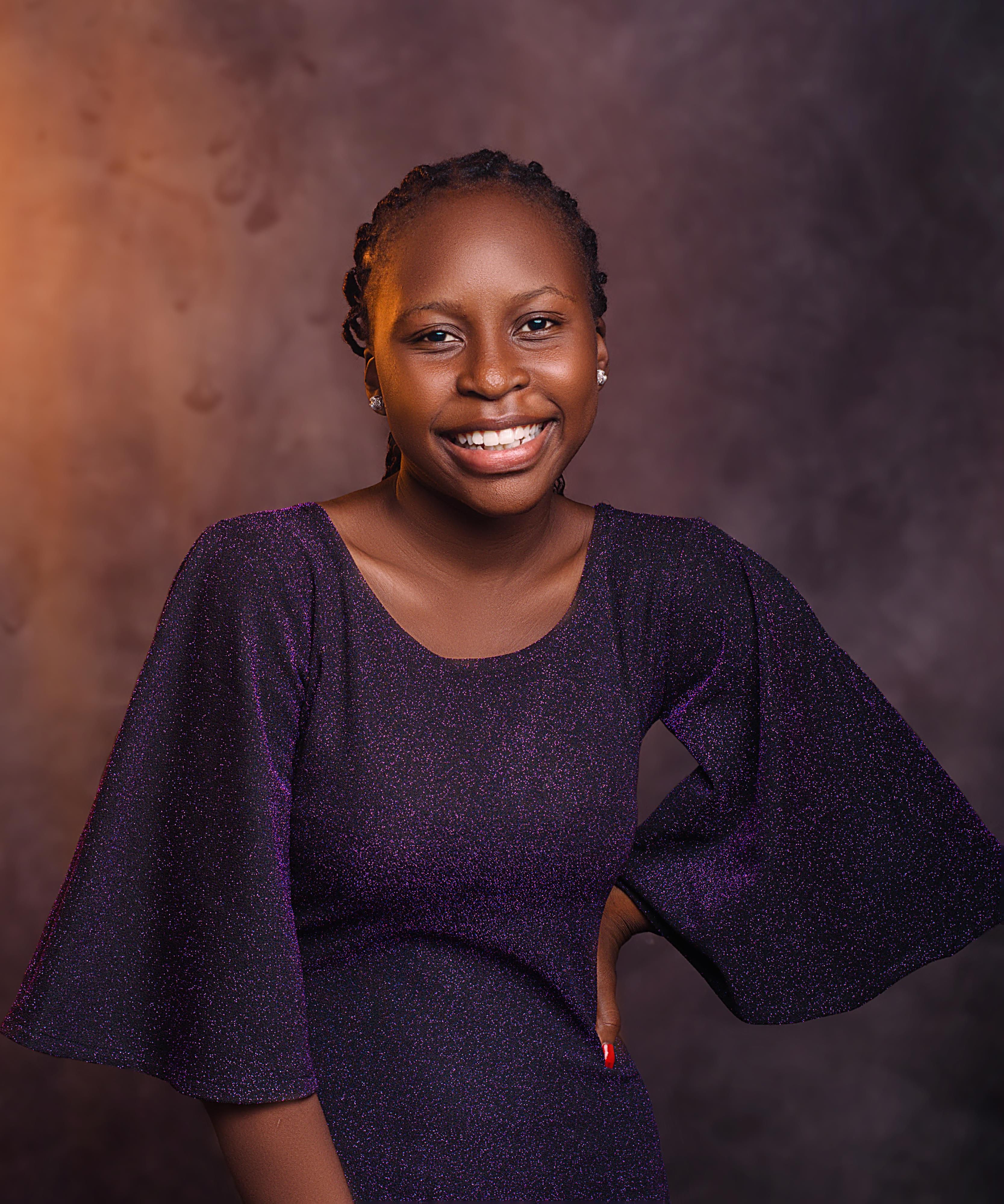 Portrait of a smiling woman in a purple dress, exuding confidence and warmth.