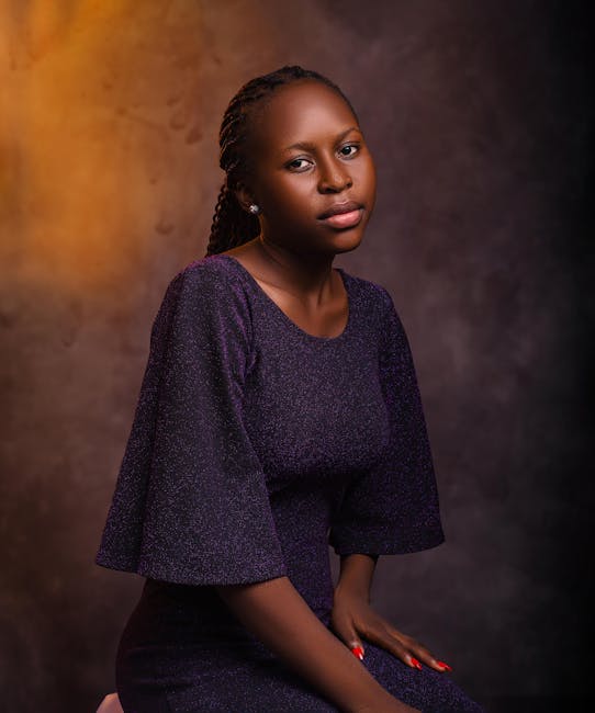 A stylish portrait of a woman in a purple dress against a textured backdrop.