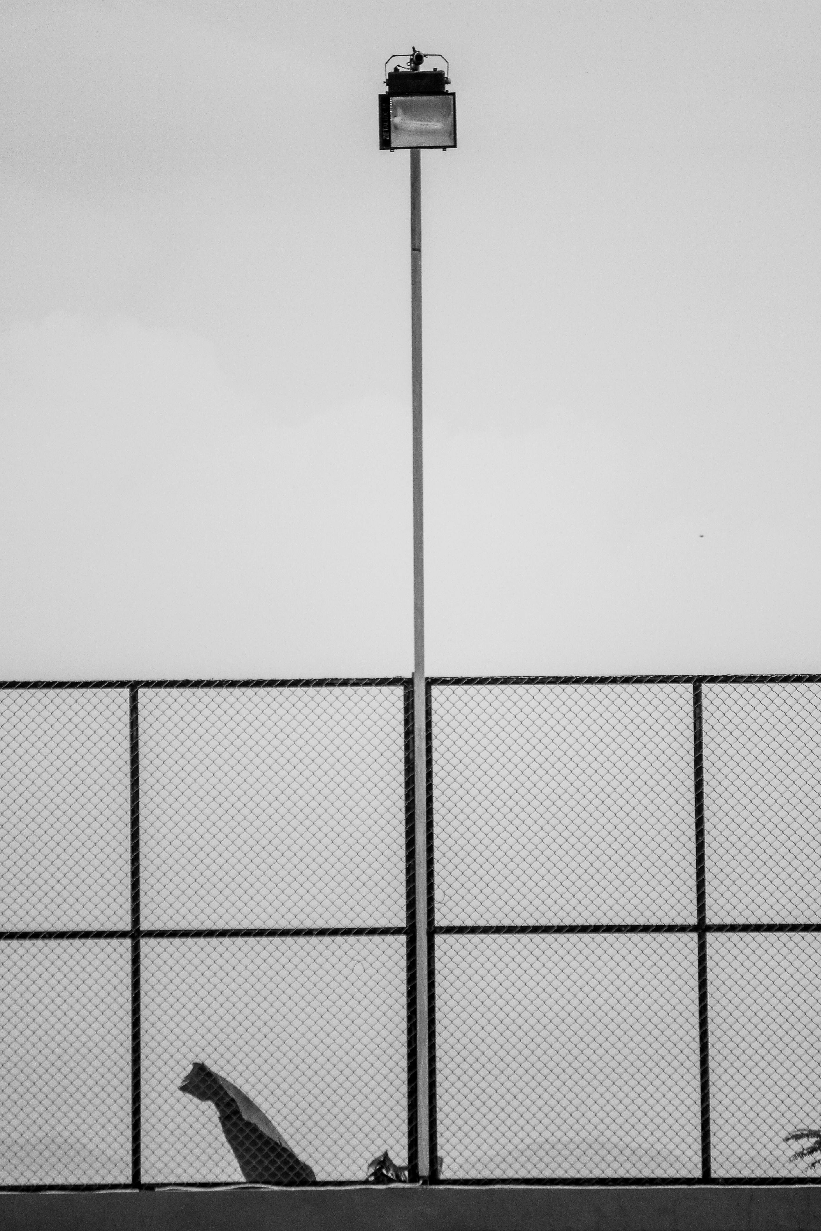 Gratis Foto minimalista in bianco e nero di una recinzione e di un lampione a Giava orientale, Indonesia. Foto a disposizione