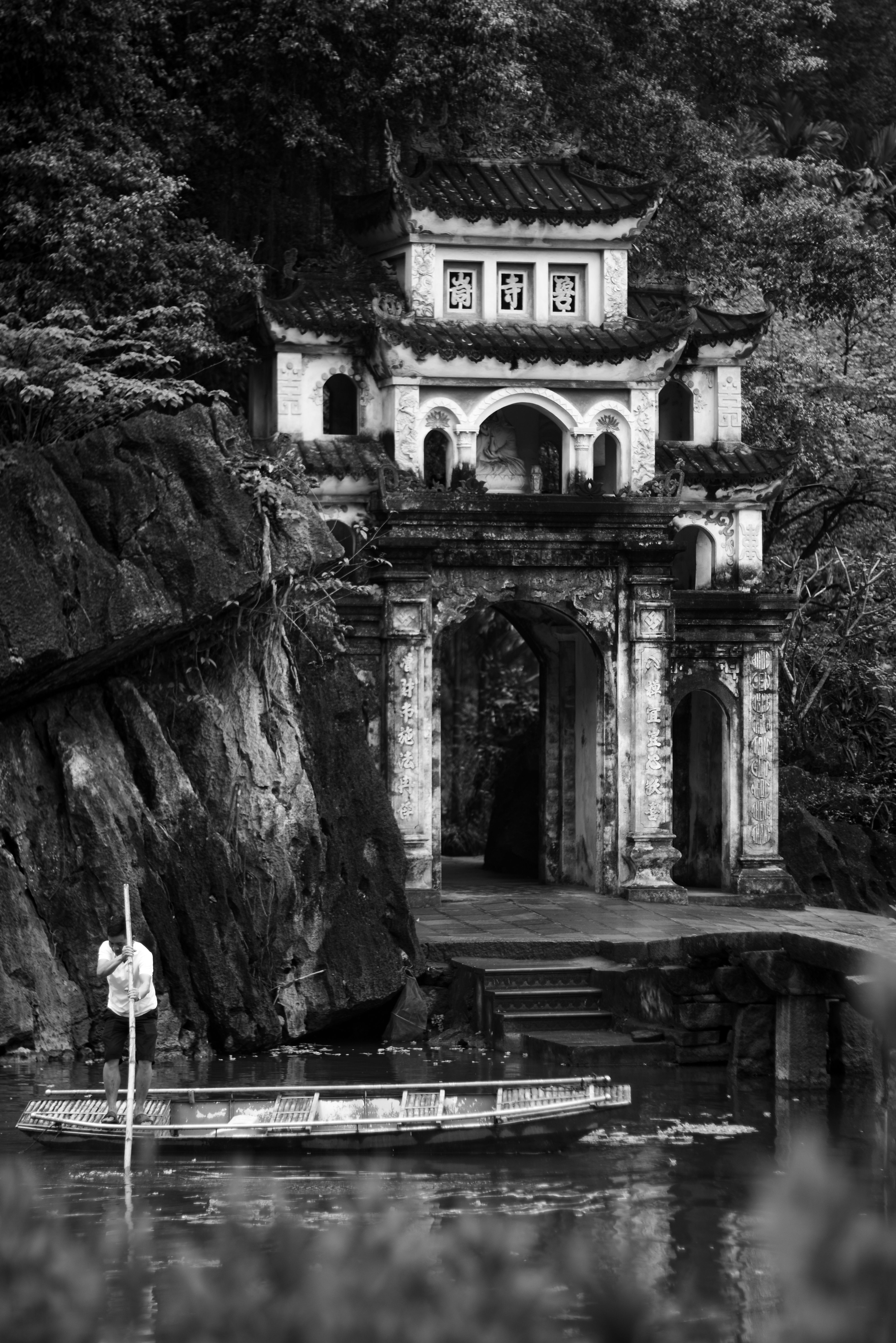 Beautiful black and white scene of an ancient temple by the river.