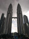 在阴沉的天空下，吉隆坡城市景观中的马来西亚国家石油公司双子塔令人惊叹