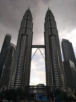在阴沉的天空下，吉隆坡城市景观中的马来西亚国家石油公司双子塔令人惊叹