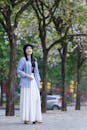 Young Woman Strolls Beneath Spring Trees in Hanoi