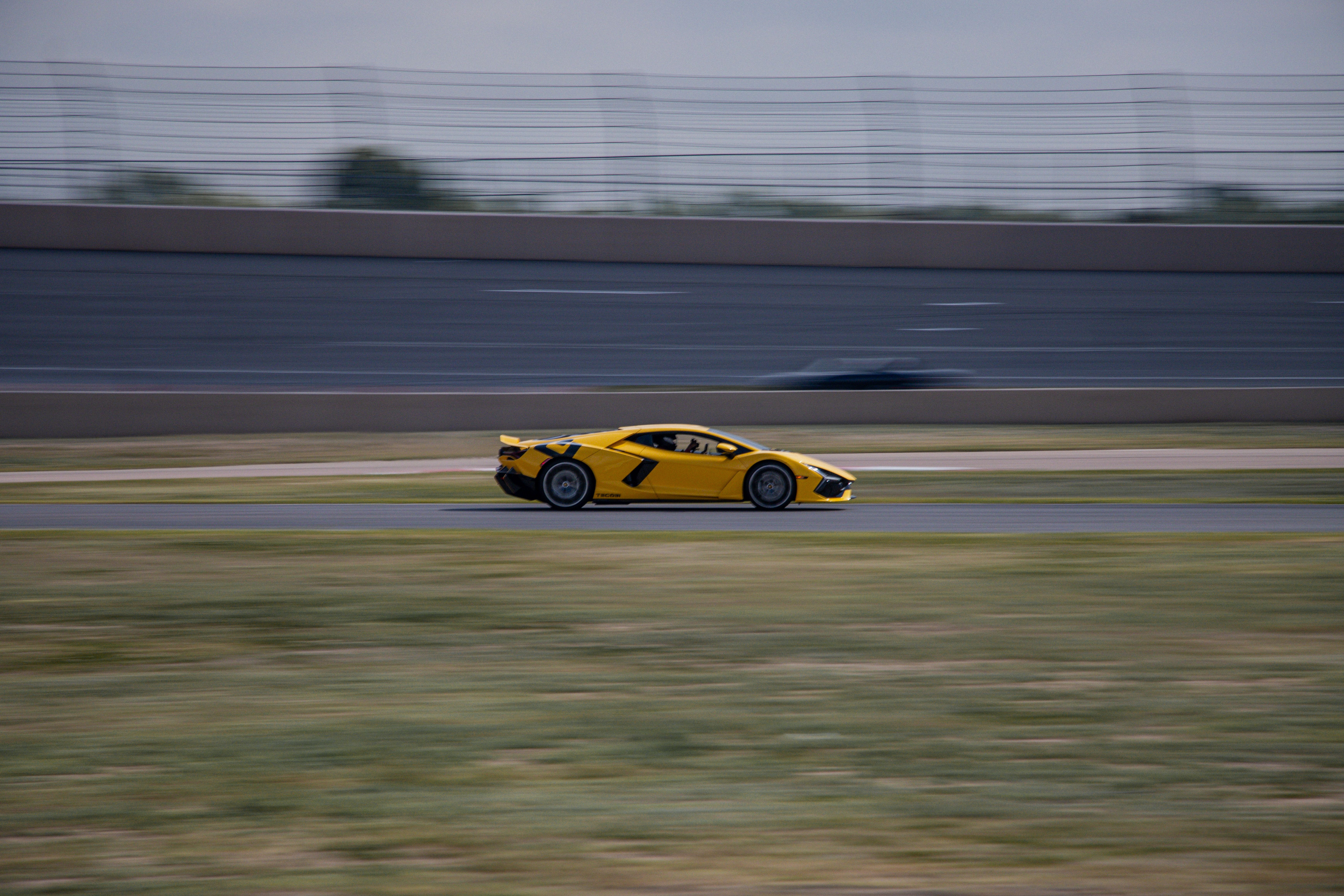 Yellow Sports Car Racing on Colorado Track · Free Stock Photo