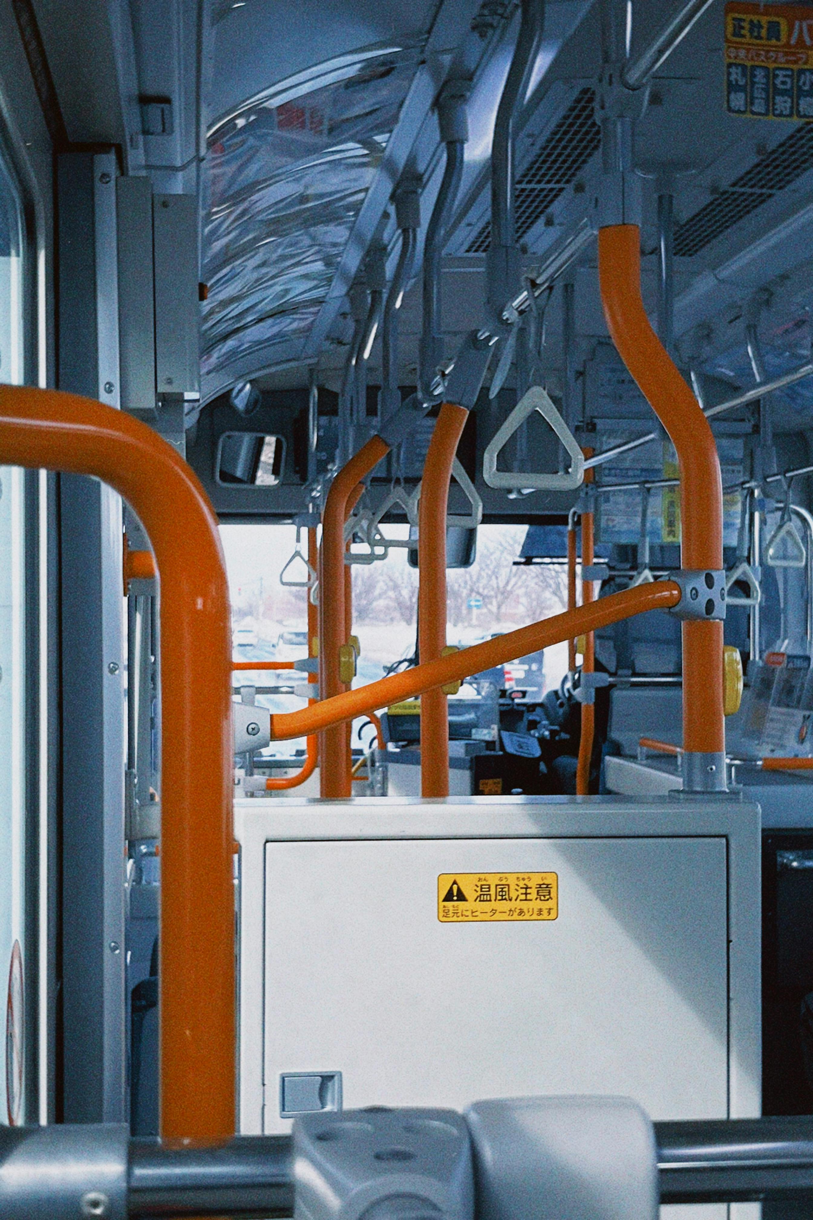 Gratis Interiøret i en tom offentlig buss i Sapporo, Hokkaido med oransje rekkverk og japansk skilting. Arkivbilde