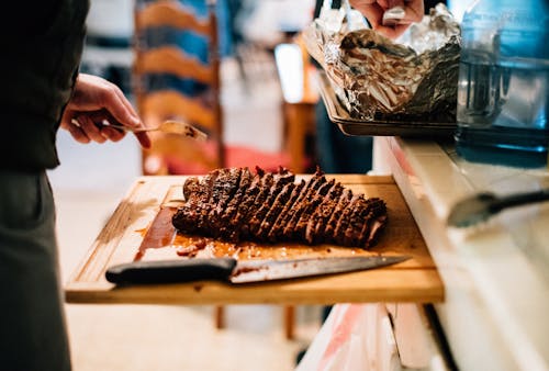 Free Person Holding Knife Slicing Meat Stock Photo