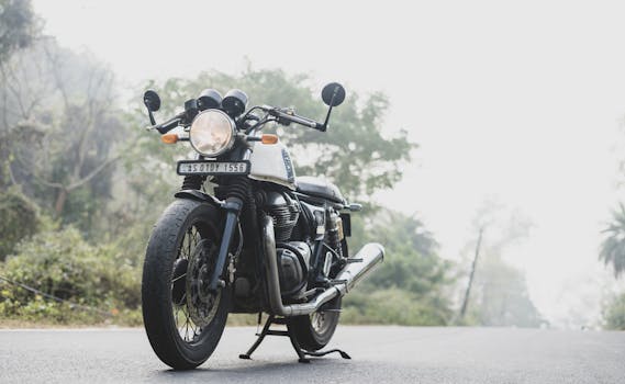 一辆老式摩托车的特写，在印度迷雾笼罩的道路上，非常适合旅行和冒险主题