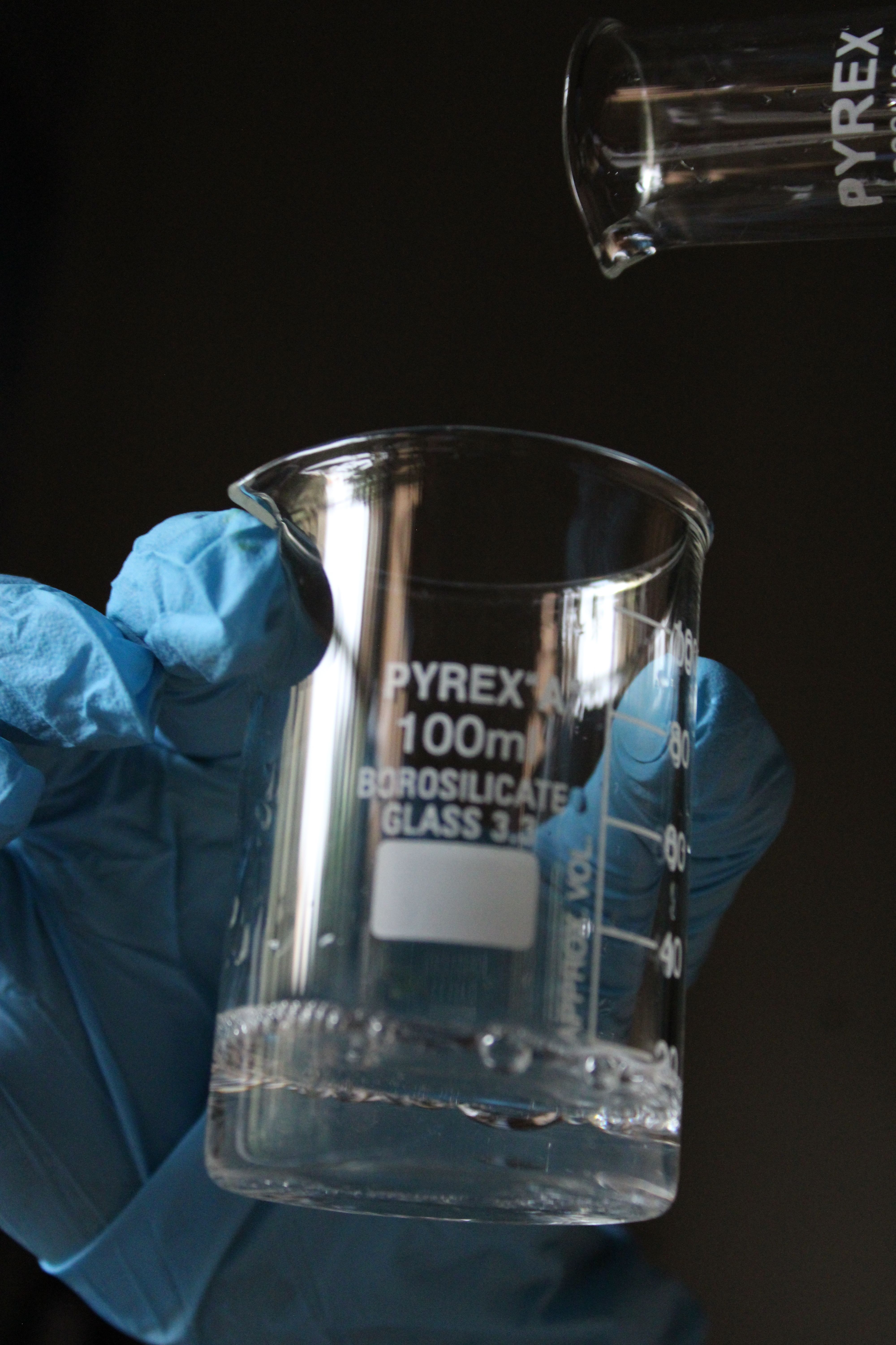 Laboratory Beaker with Yellow Liquid in Gloved Hand · Free Stock Photo
