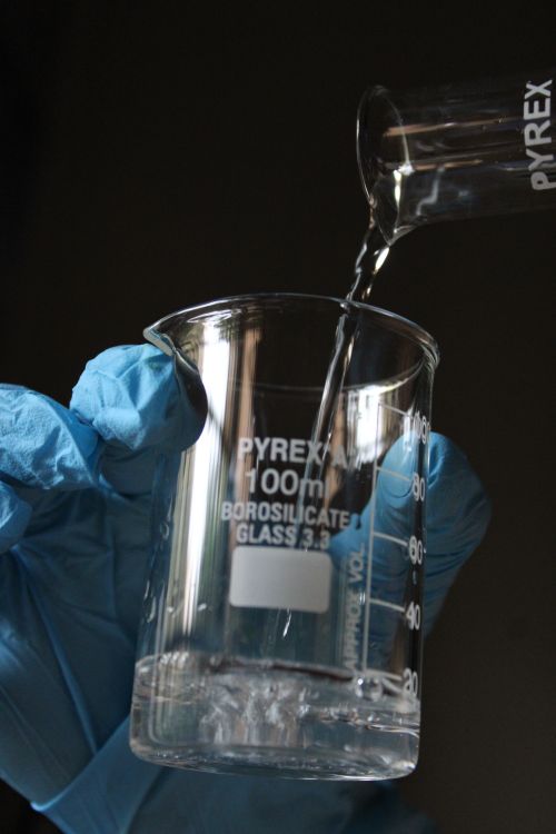 Science Pyrex Pouring Liquid into Pyrex Measurement Beaker · Free Stock Photo