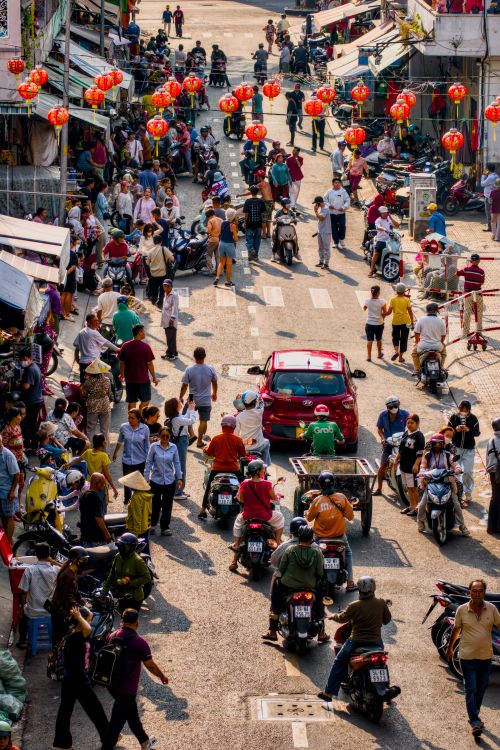 Free A vibrant street scene filled with people and motorcycles under decorative lanterns. Stock Photo