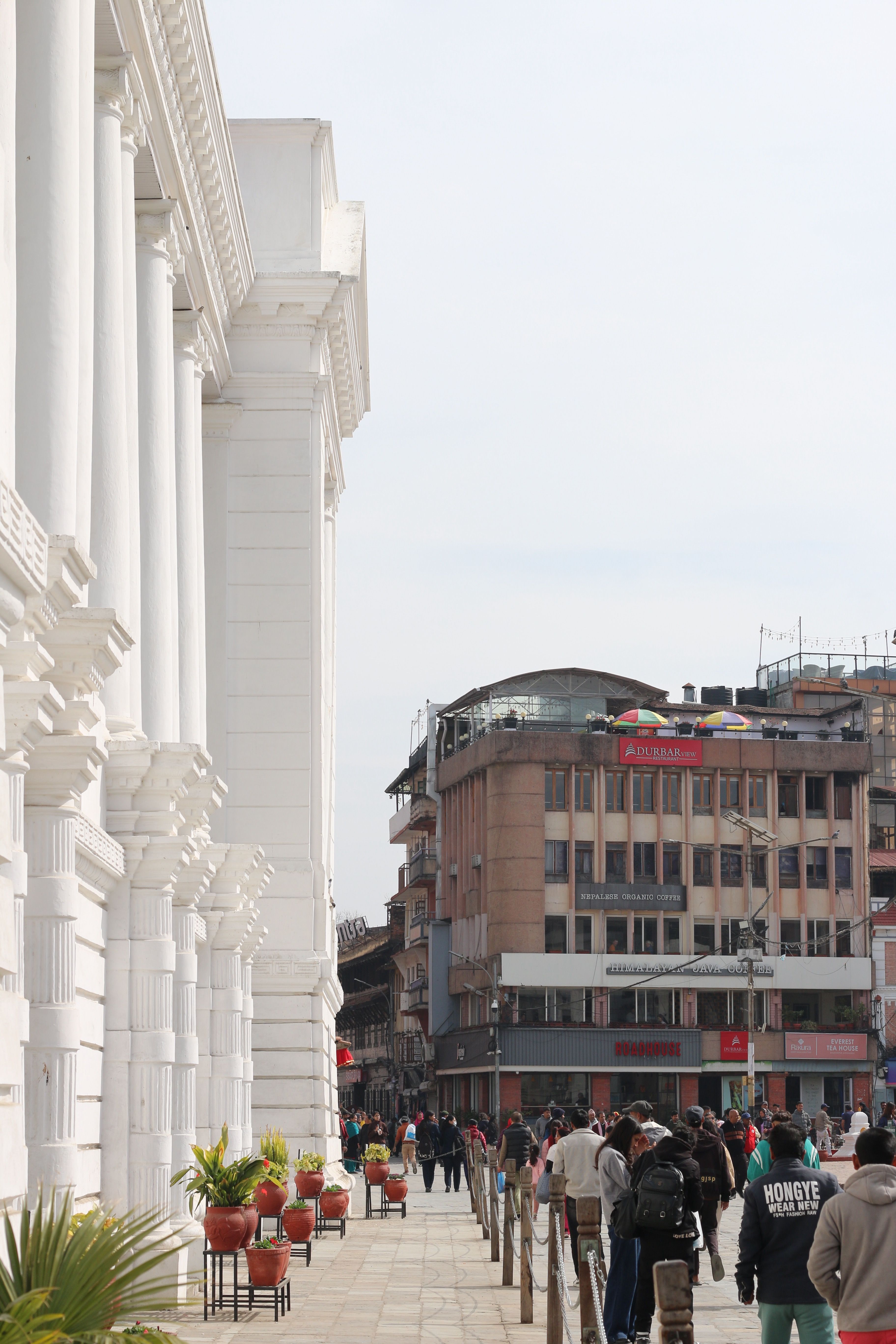 Street view in Kathmandu with historic architecture and lively crowd.