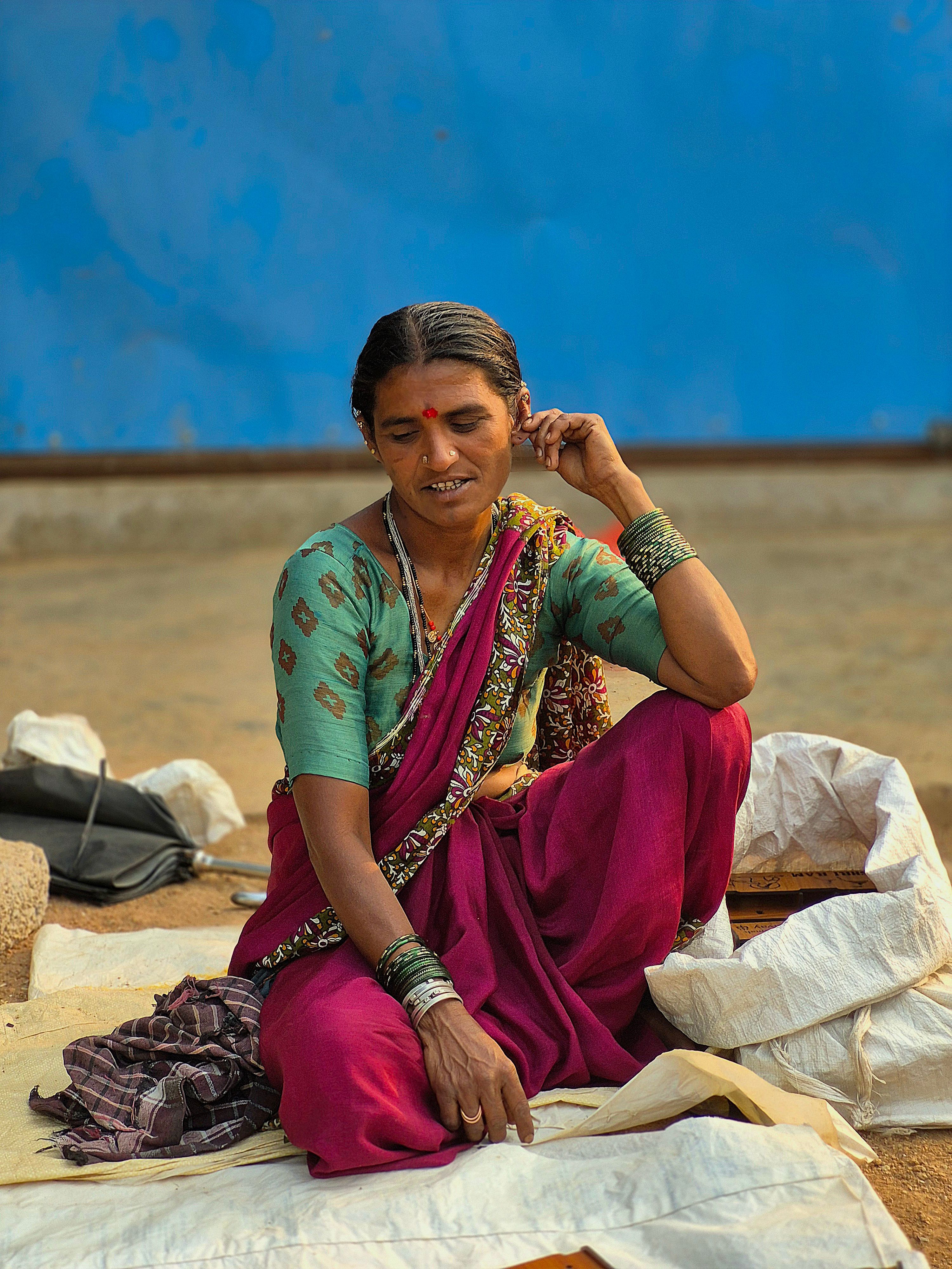 Woman in Traditional Attire Sitting Outdoors · Free Stock Photo