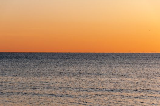 Stunning ocean sunset scene featuring vivid orange sky and calm waters, perfect for relaxation and tranquility.