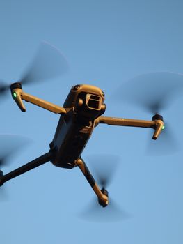 Detailed shot of a drone flying with clear blue sky background.