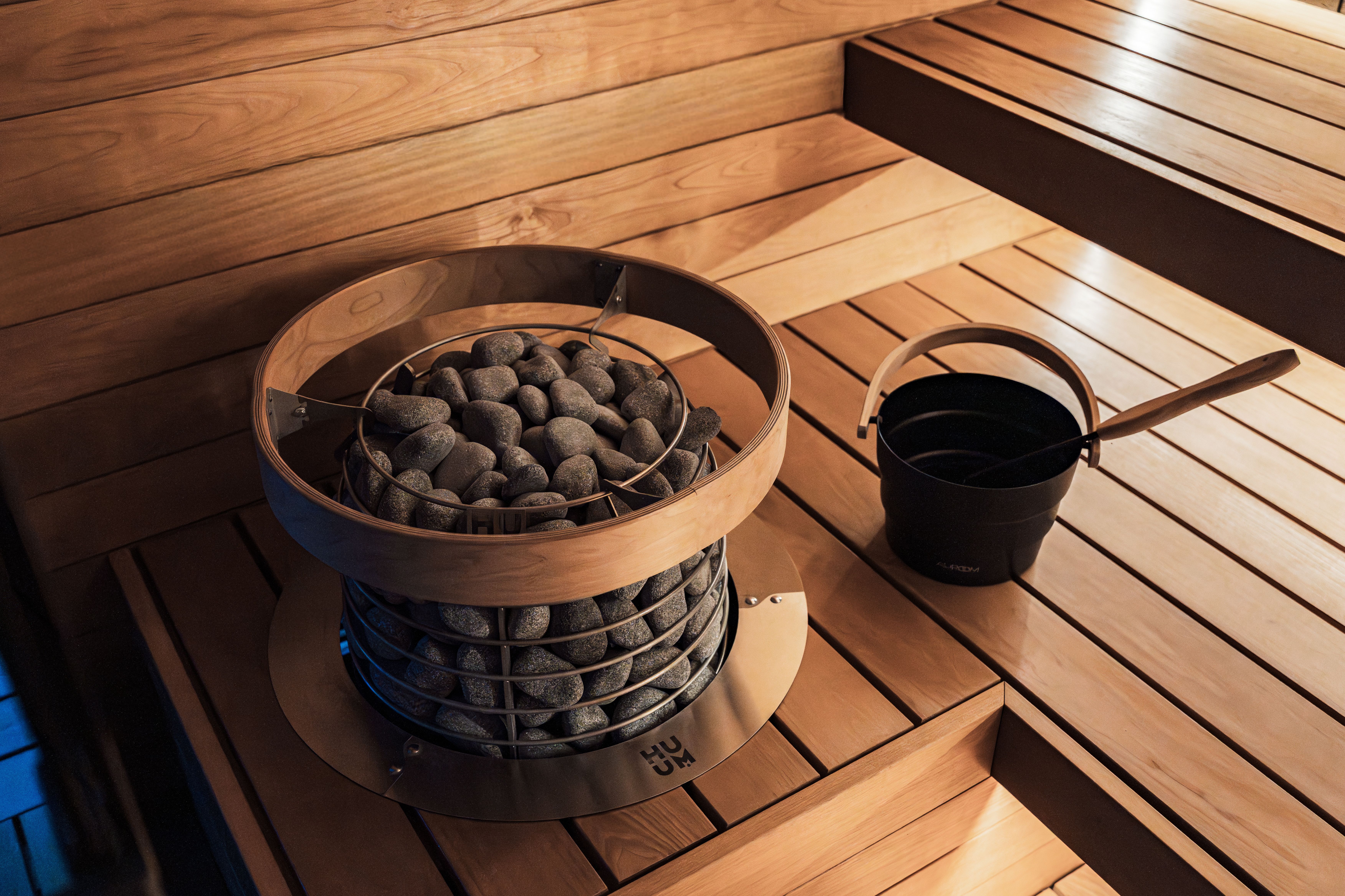 Elegant indoor sauna featuring a modern heater and wooden design elements.