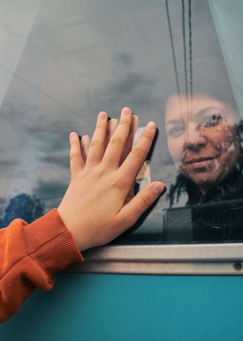 Free A touching moment captured of a hand on a train window, symbolizing farewell and emotion. Stock Photo