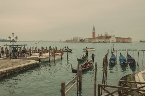 Free Explore the picturesque canals of Venice with gondolas, historic buildings, and vibrant waterfront life in a serene setting. Stock Photo