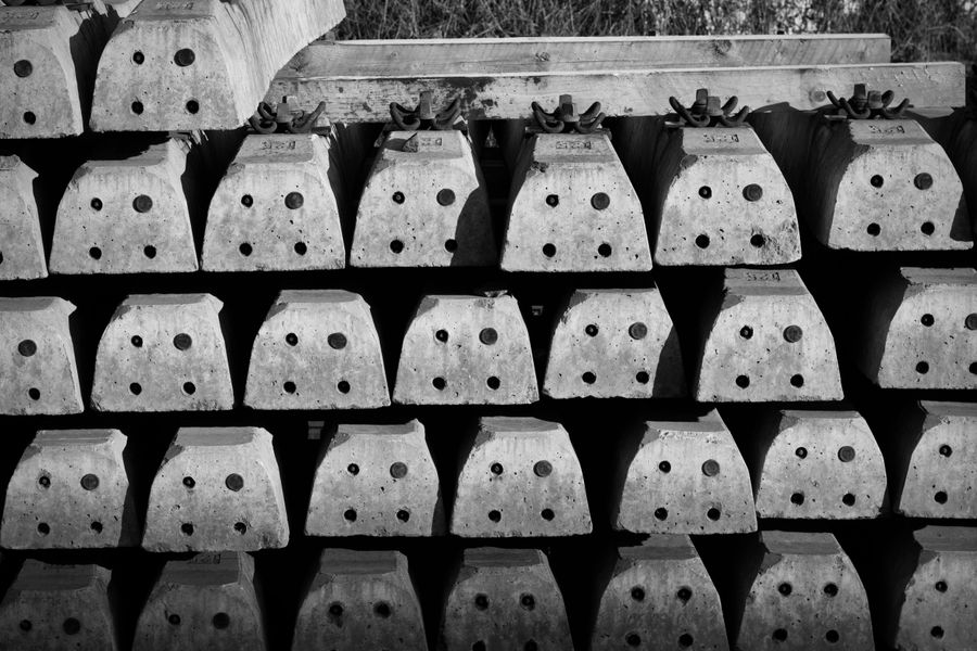 Black and white photo of stacked concrete blocks with a repetitive pattern.