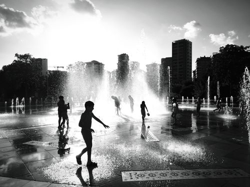 Free Black and white photo of people playing in a fountain at İstanbul. Silhouettes create a dynamic scene. Stock Photo