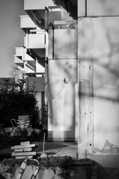 Monochrome view of an unfinished urban building facade with shadows.