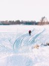 一名孤独的滑雪者穿过白雪皑皑的风景，滑行在冬季森林附近风景优美的滑雪道上