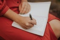 Woman Writing in Journal Wearing Red Dress