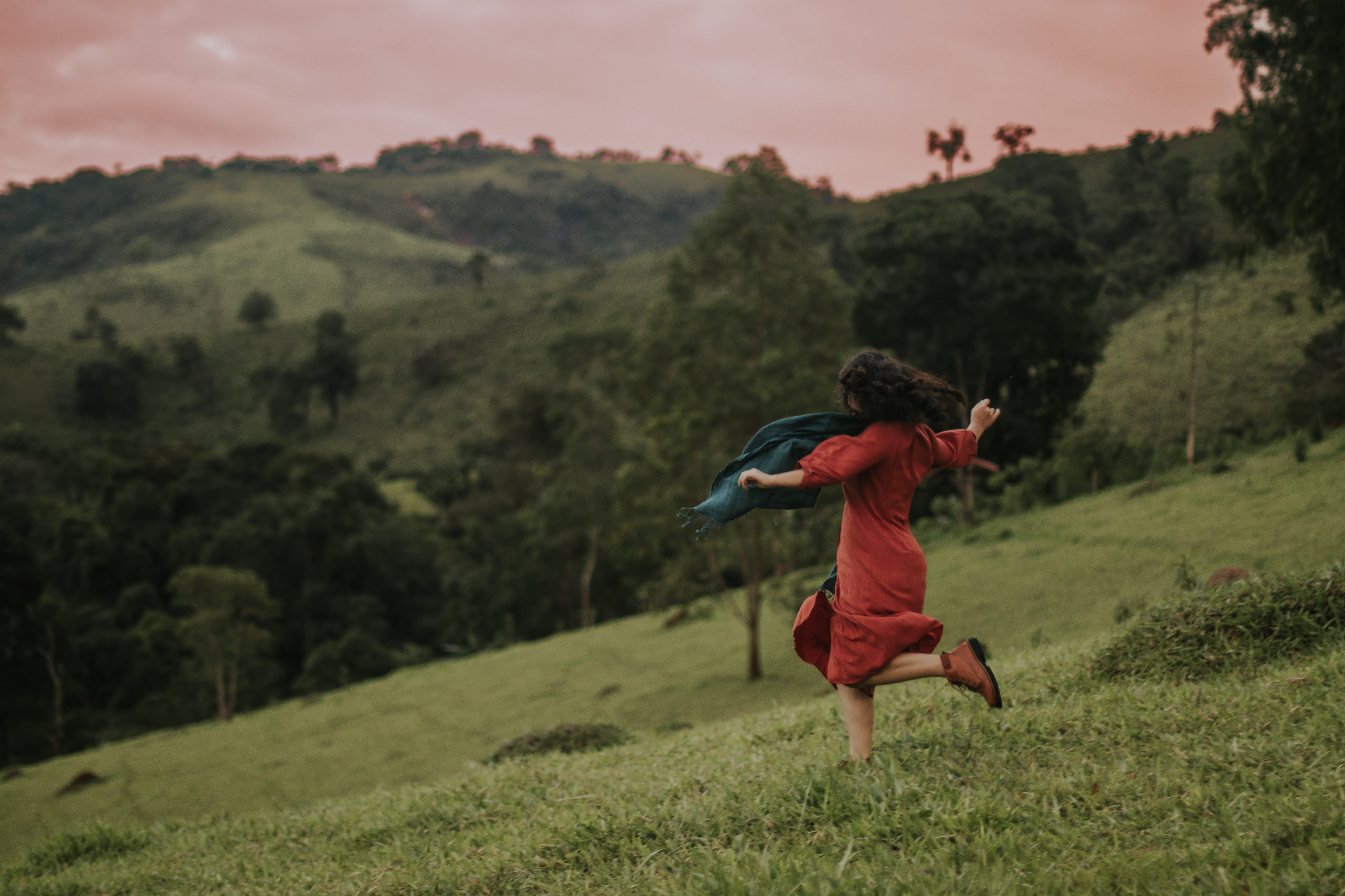 A woman standing on a hilltop embracing the open sky with a sense of freedom