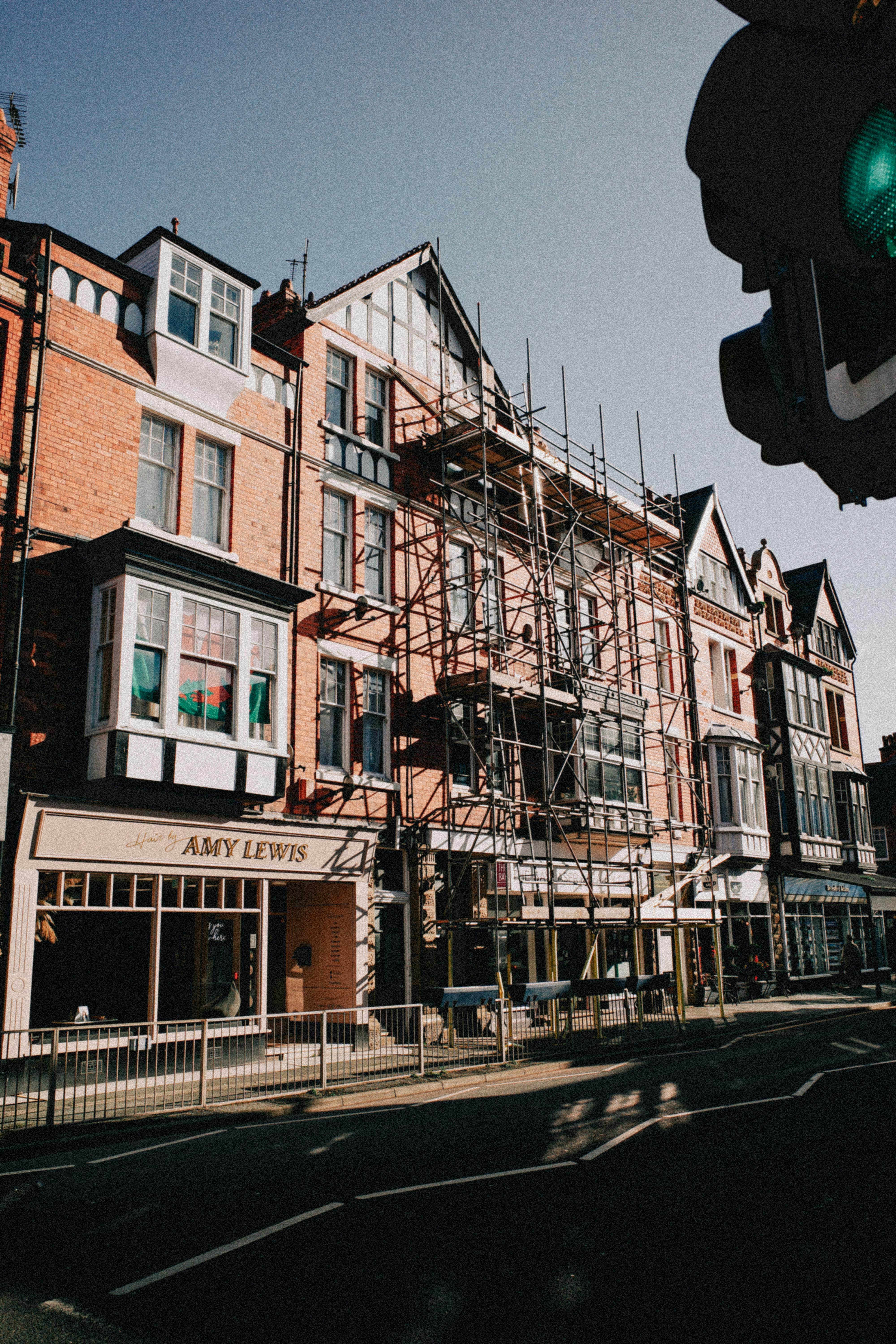 Traditional architecture and scaffolding under the bright sun in Colwyn Bay, Wales.
