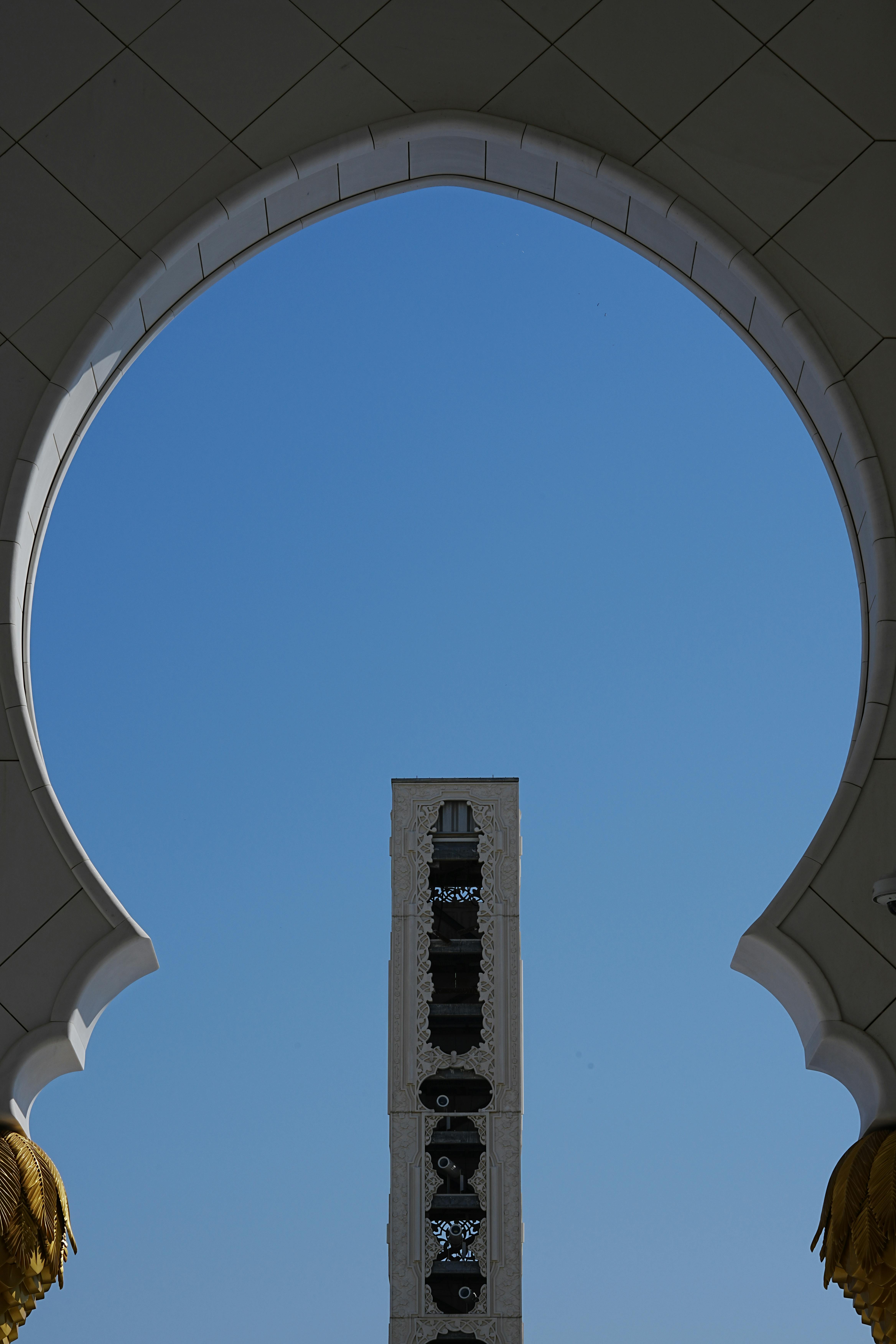 無料 澄み切った青空を背景に印象的なアーチを備えたエレガントな UAE 建築。 写真素材