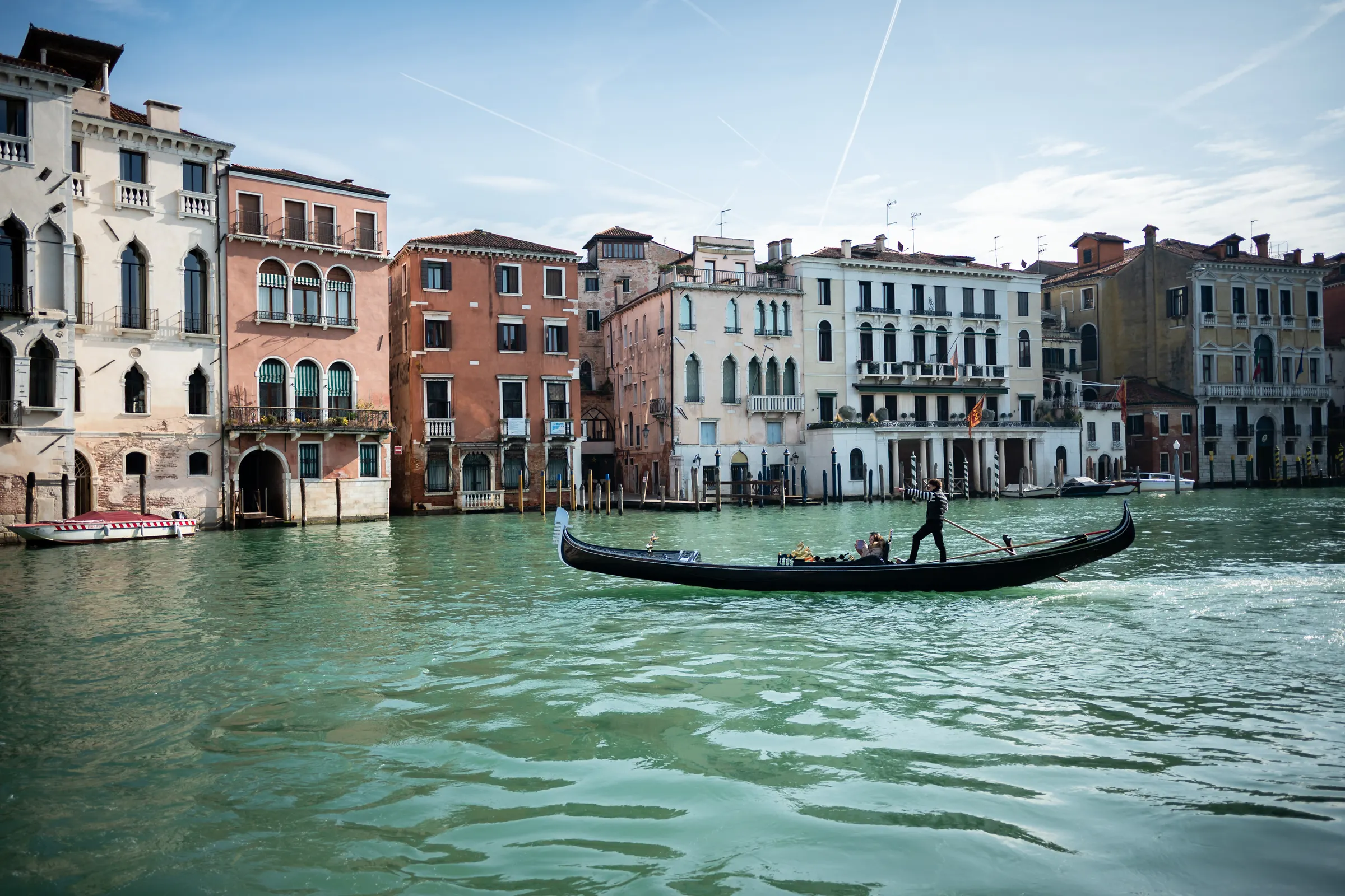 Gondola menyusuri Grand Canal Venesia, diapit bangunan bergaya Venesia di kedua sisi kanal, Italia
