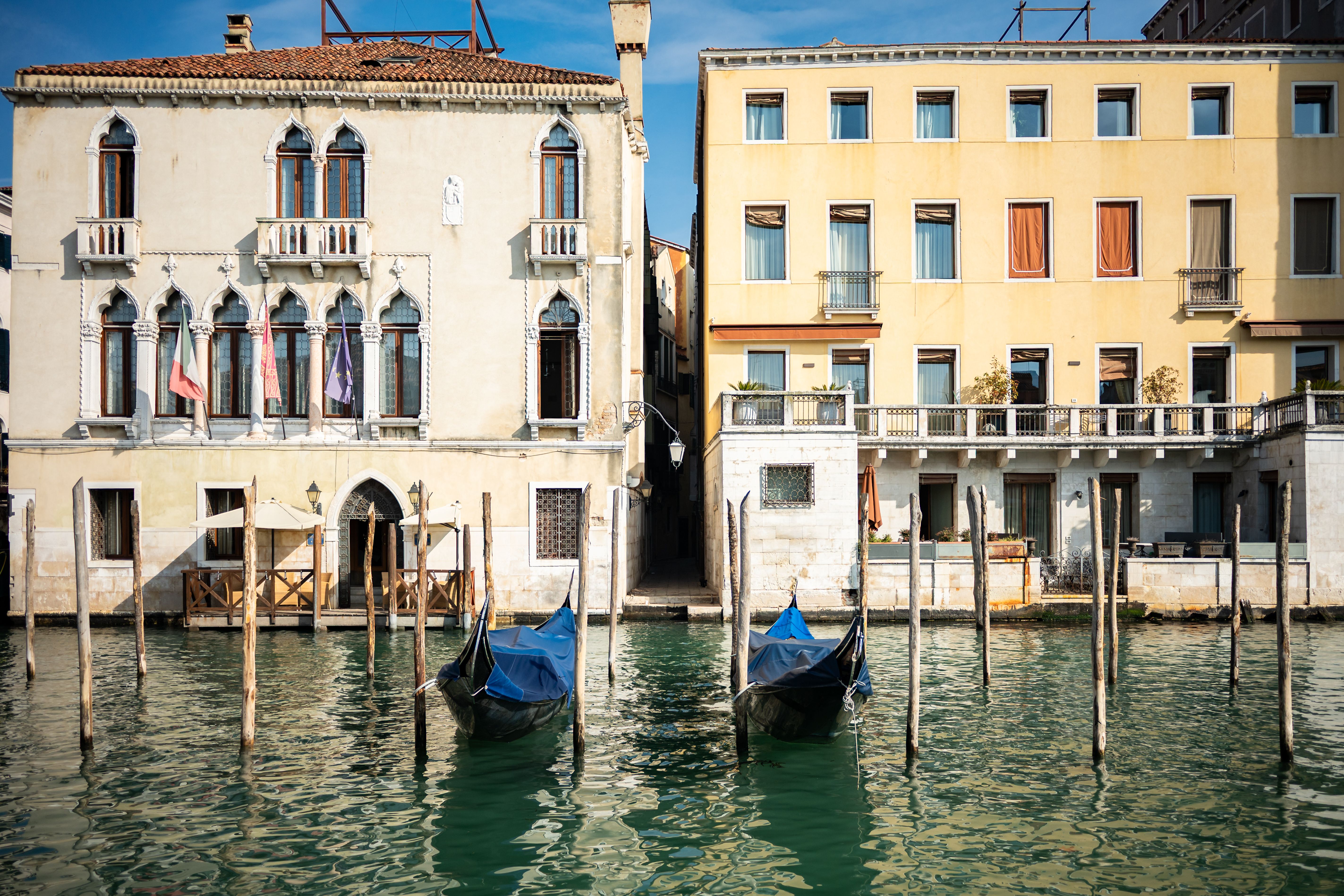 Charming Venetian architecture facing a canal with two gondolas docked. Perfect for travel inspiration.