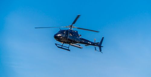 Free Aerial view of a helicopter flying against a clear blue sky, showcasing aviation and adventure. Stock Photo