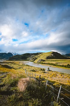 Panoramic view of El Chaltén's lush valleys and winding rivers under dramatic skies.