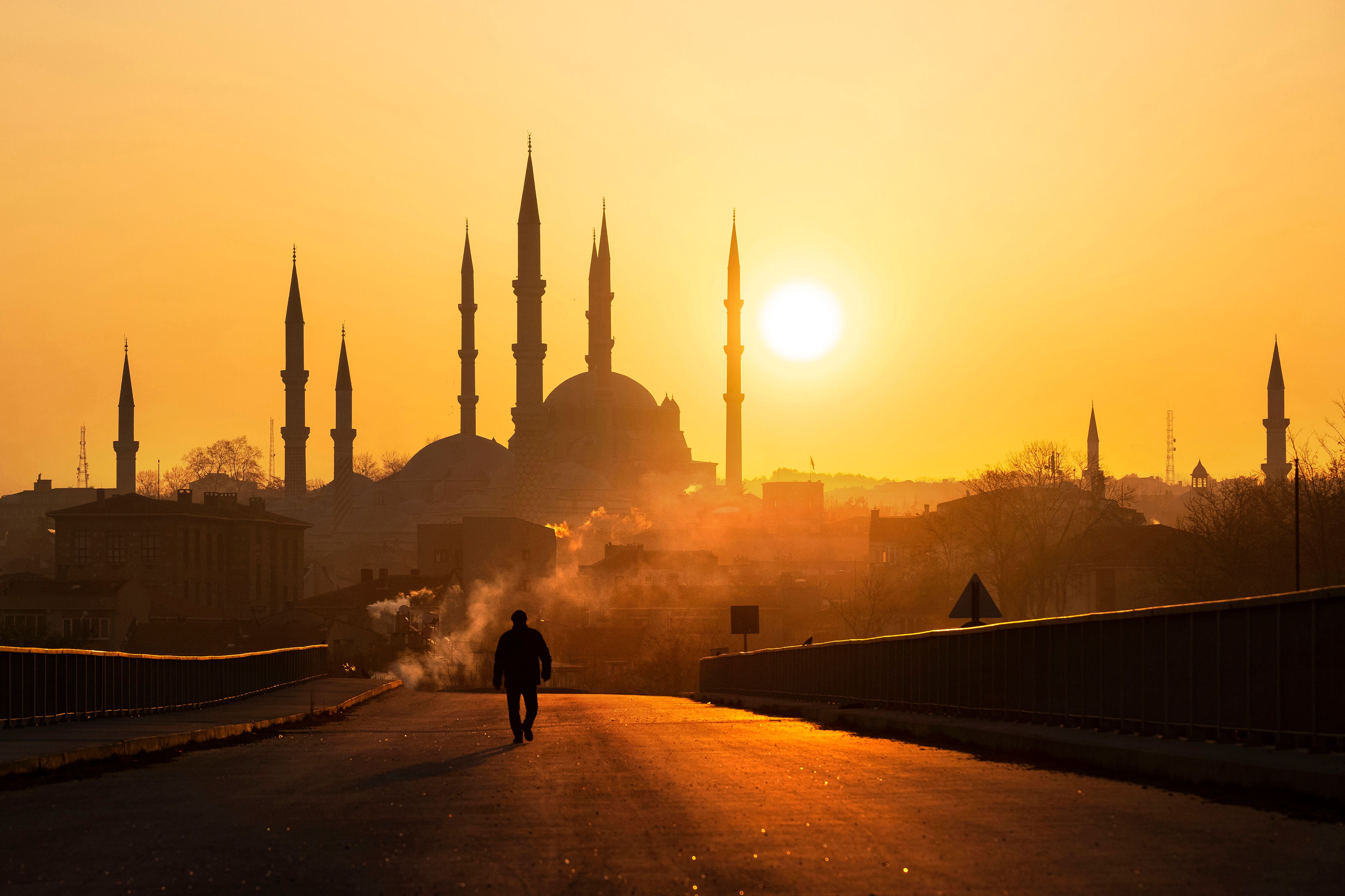 A stunning view of Selimiye Mosque silhouette at sunset, with a lone figure walking down an empty street.