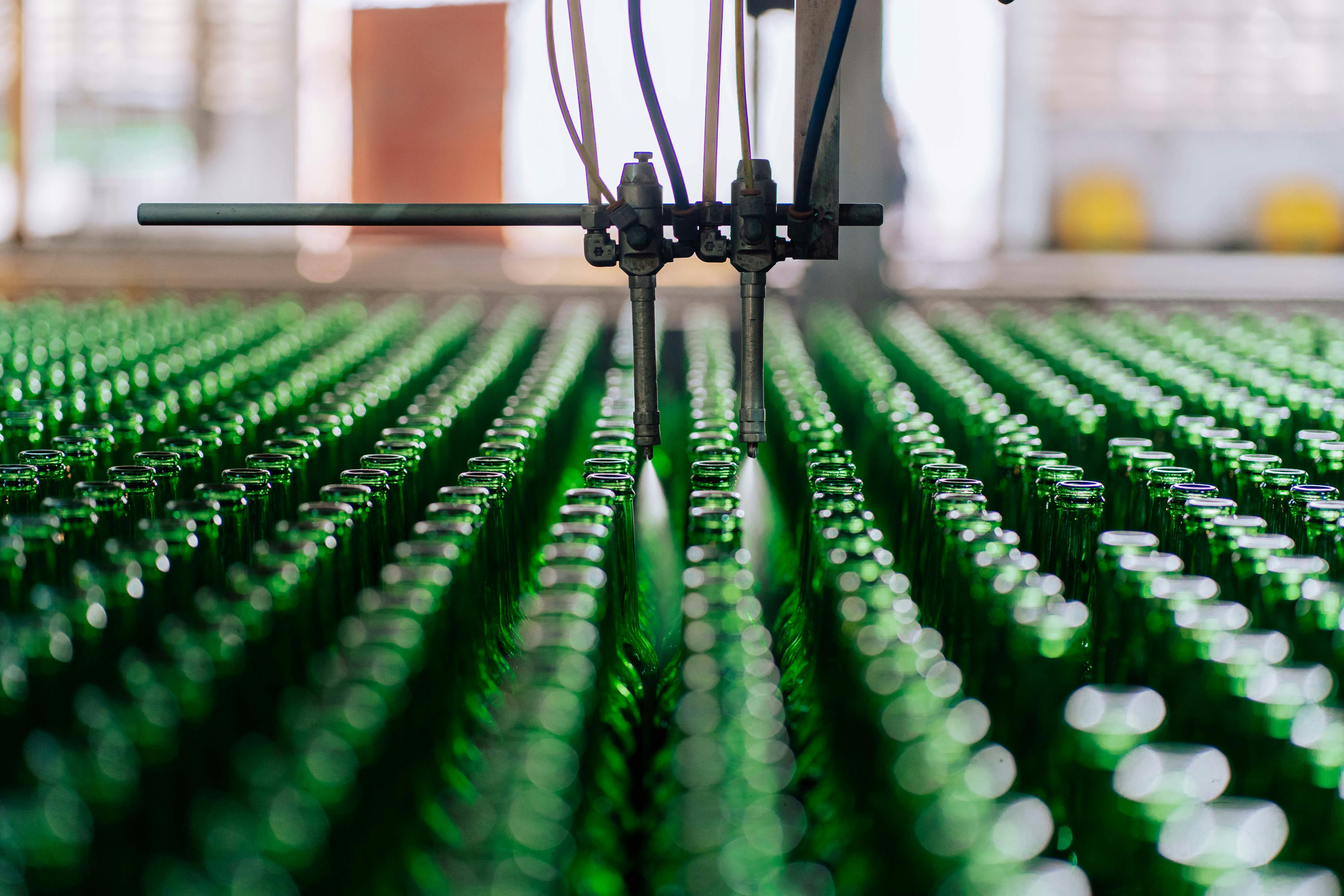 Glass bottles on an automated line in a factory, showcasing industrial glass making. — What's New in Packaging machinery...