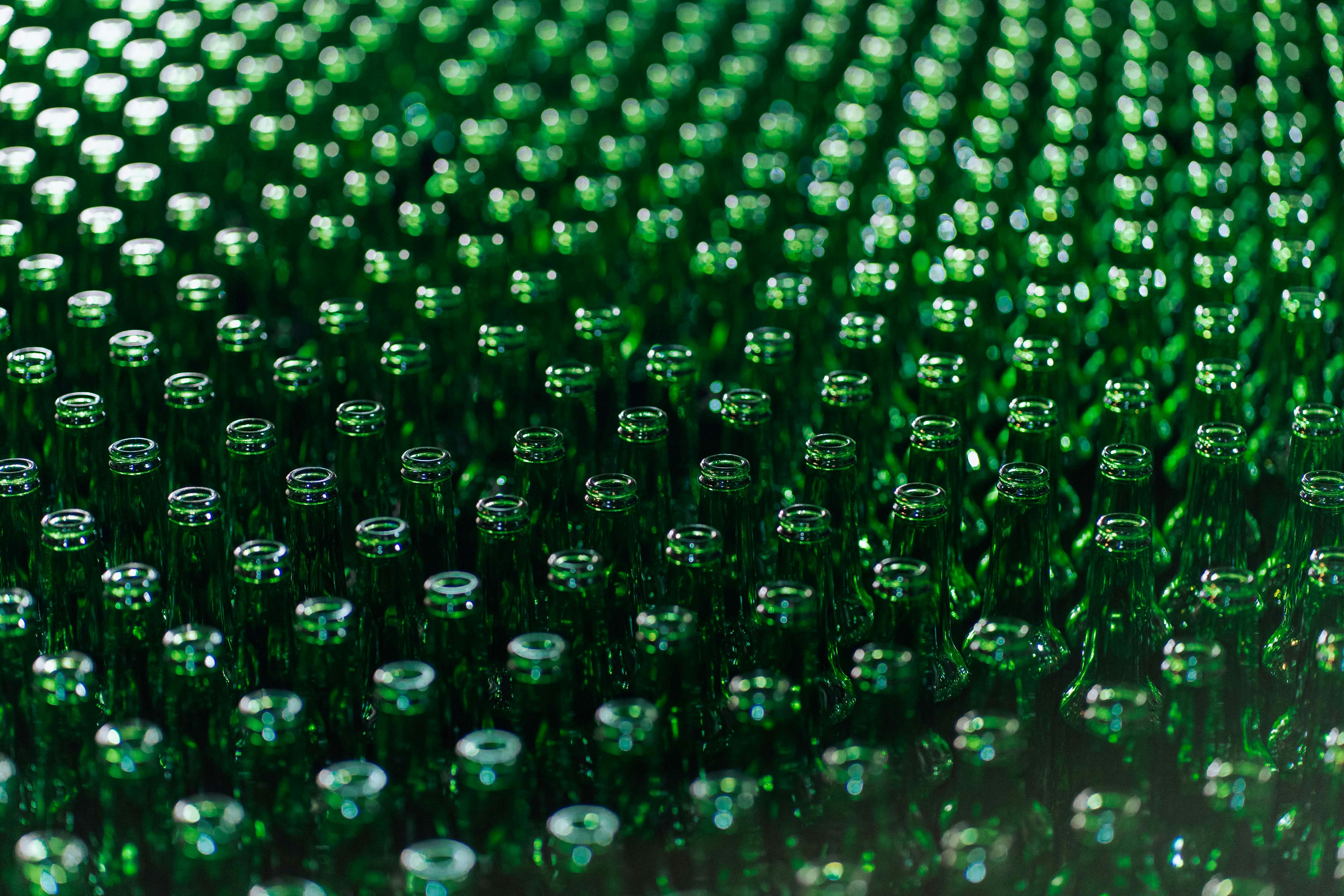 Gratuit Vedere în prim-plan a numeroaselor sticle de sticlă verde aliniate într-o fabrică, demonstrând simetria industrială. Fotografie de stoc